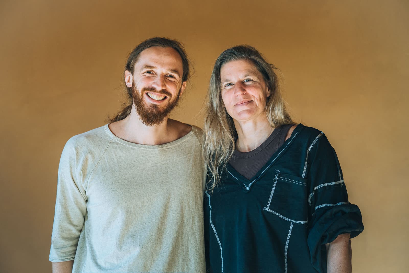 Daniel Alan und Caroline Nyfeler gemeinsam vor einer warmen Wand.